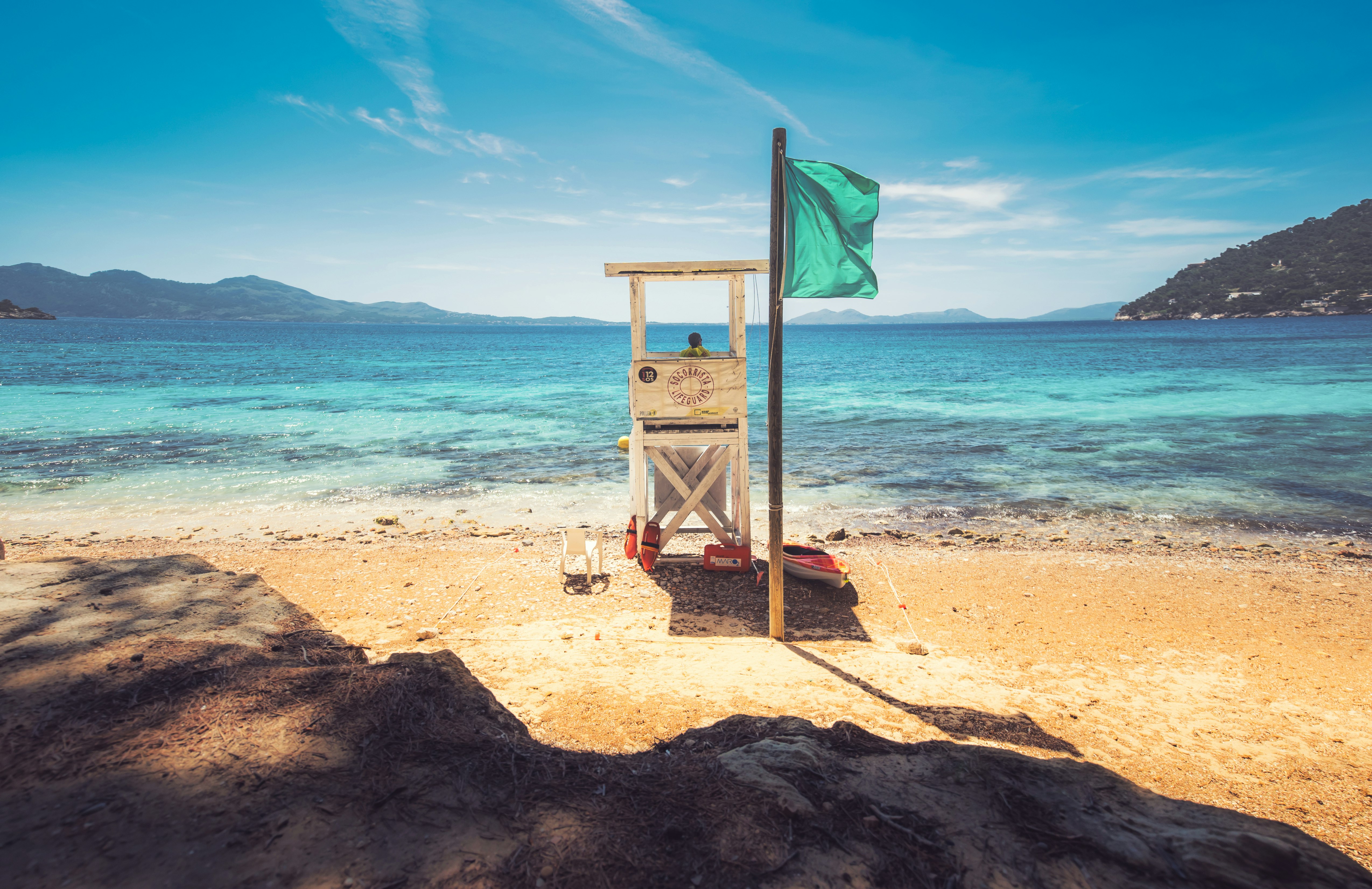 brown wooden lifeguard tower on beach shore during daytime